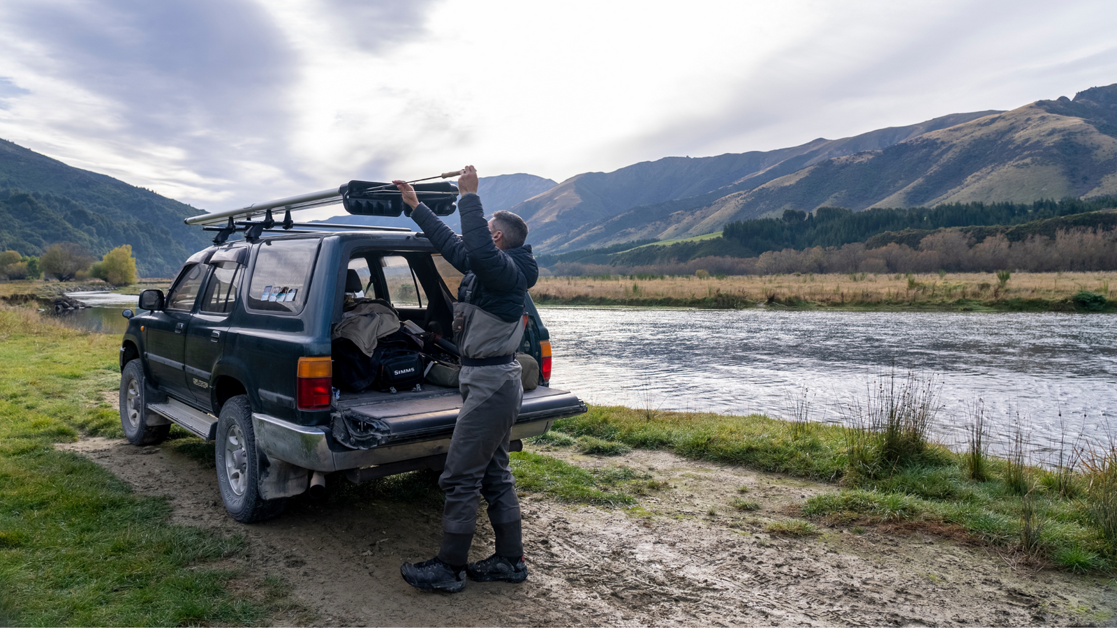 4-Banger River Quiver being loaded up with a fly rod next to a scenic spot on the river