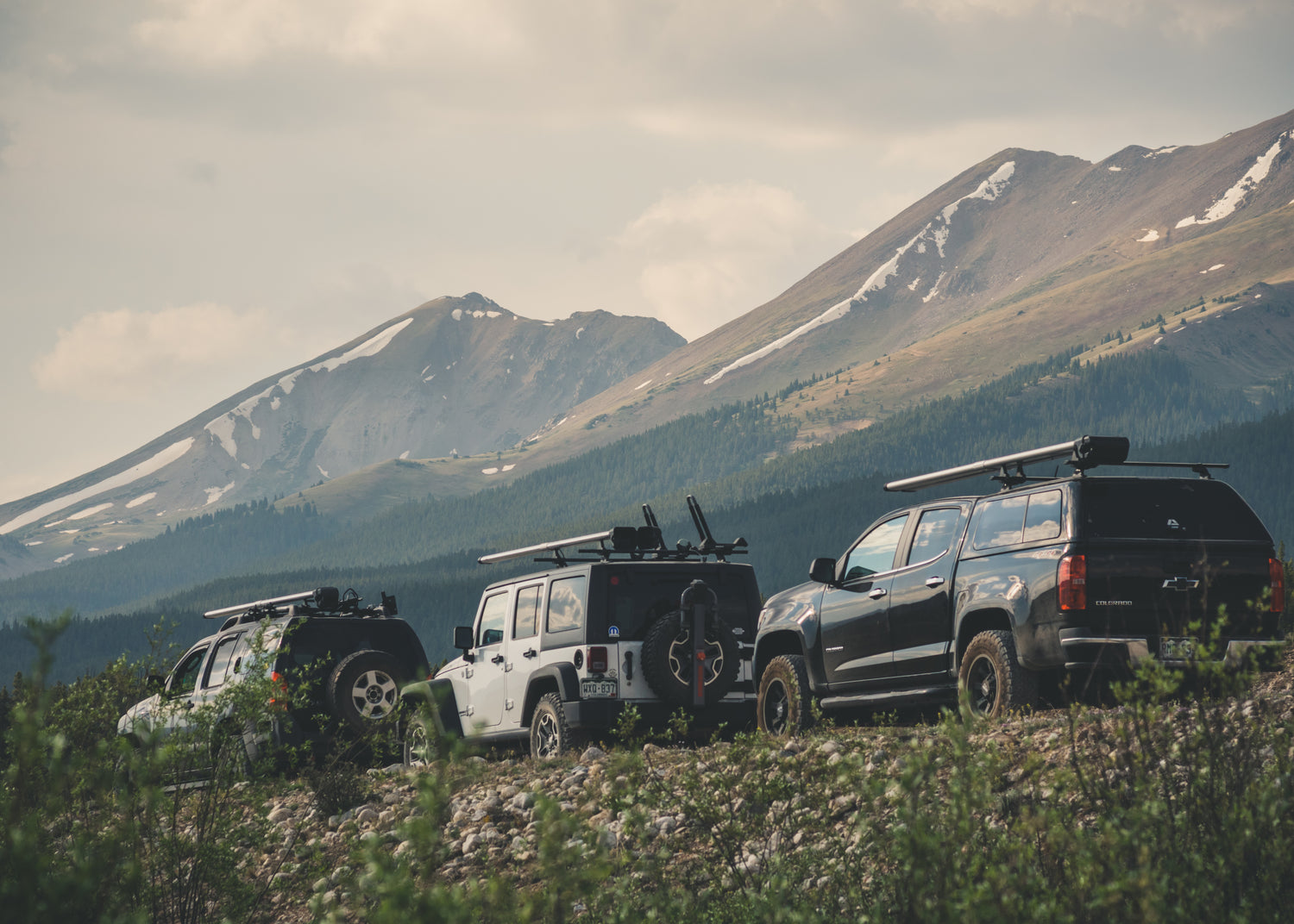 Caravan of three vehicles rigged with River Quivers by Riversmith on the road to a beautiful fly fishing spot in the Rocky Mountains